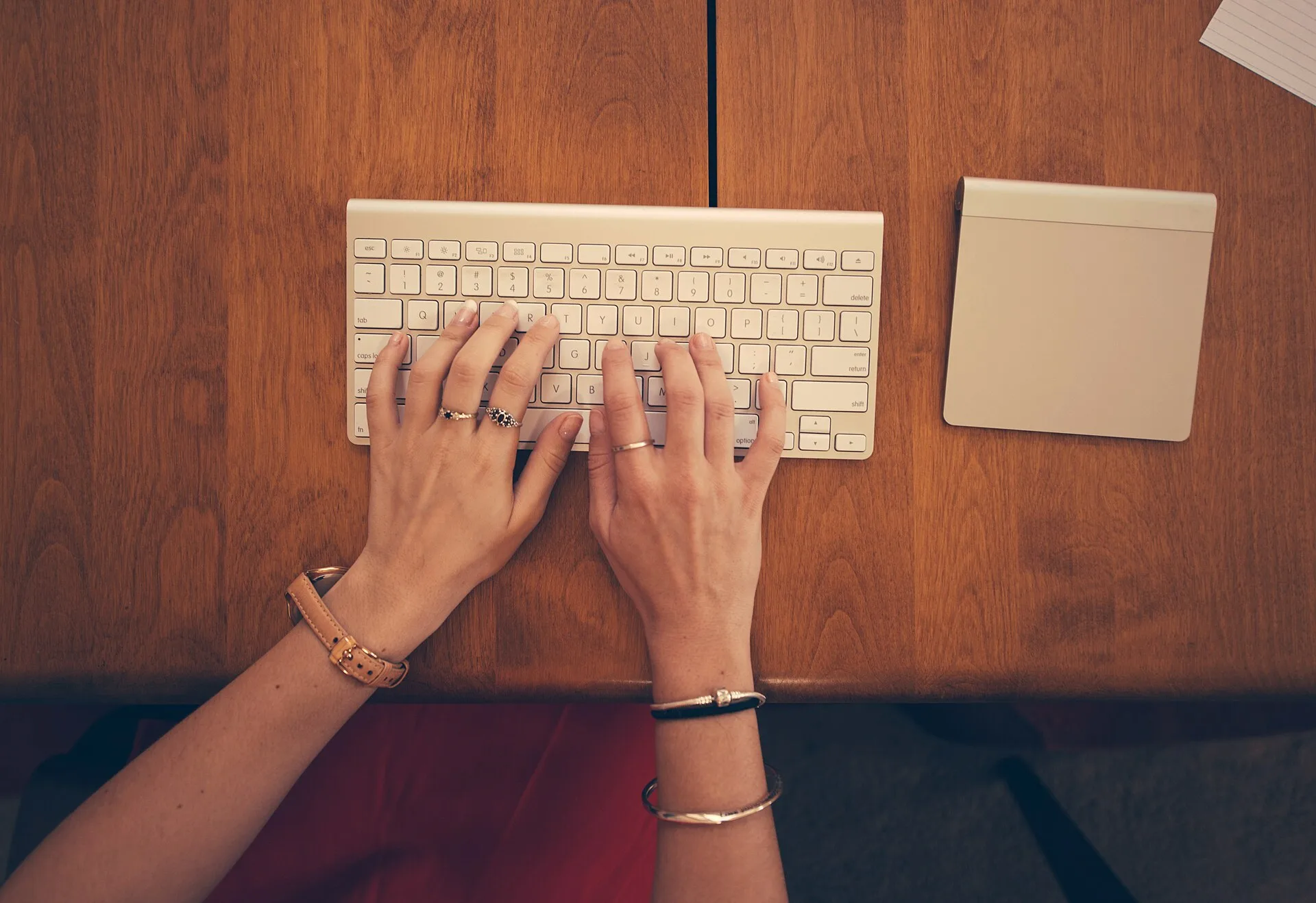 Hands typing on a keyboard viewed from above